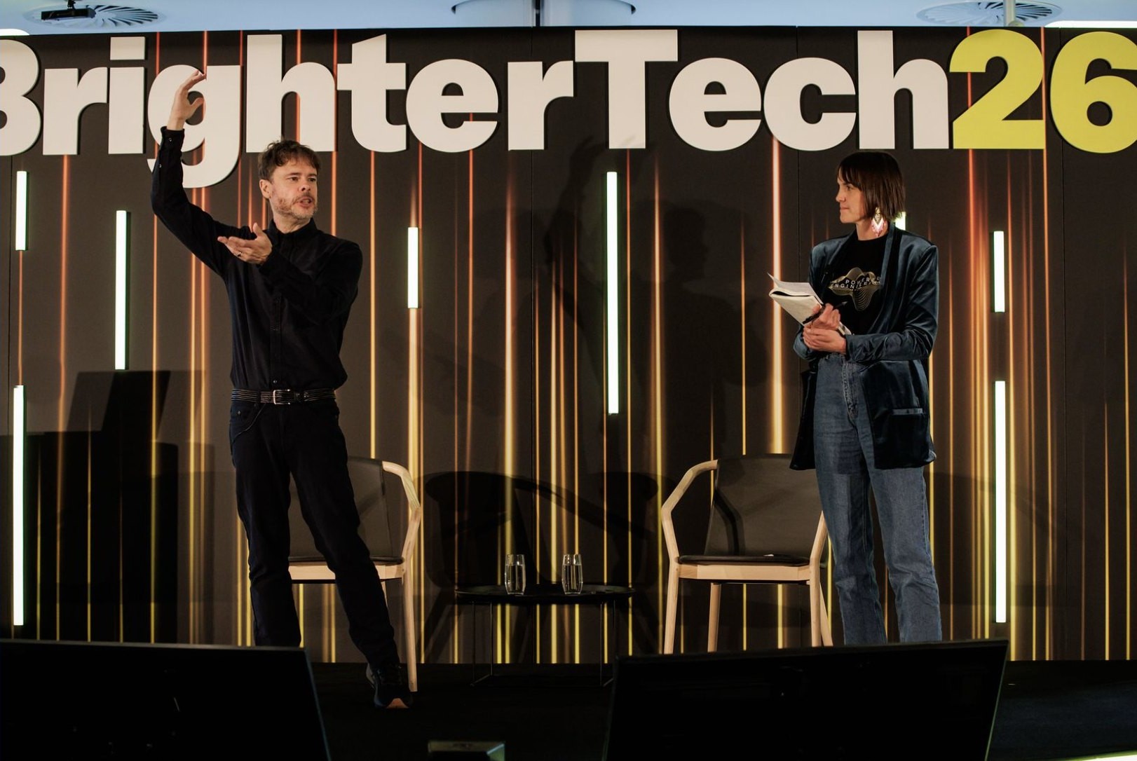 Steve Yegge on stage at Commonwealth Bank's BrighterTech26 in Sydney, mid-gesture beside the session moderator — September 17, 2026