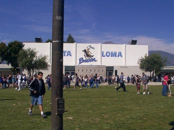 Alta Loma High School — the campus building lettering and Braves mascot, with students on the field
