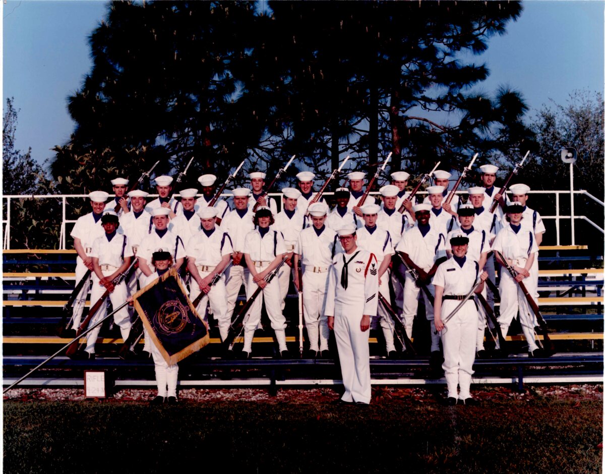 U.S. Navy drill team in dress whites with rifles and a guidon, posed on bleachers — Steve Yegge among them, Orlando