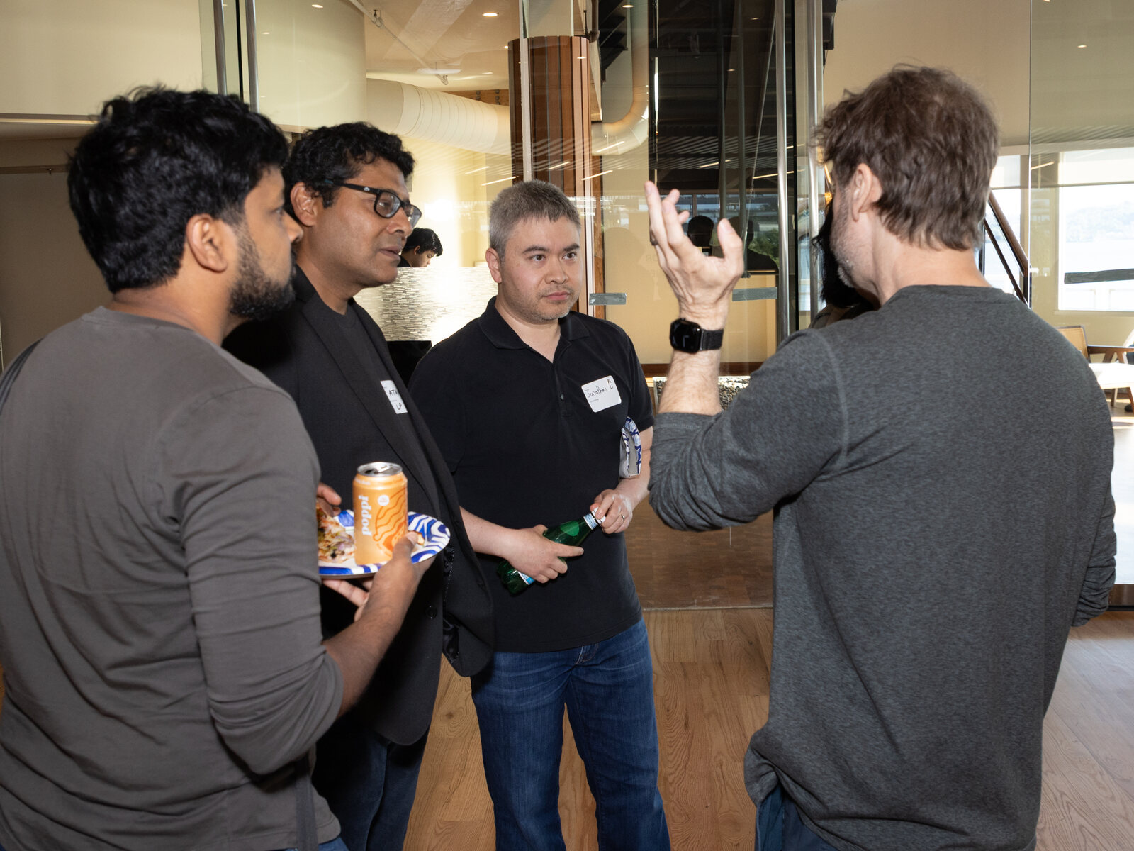Steve Yegge in a standing conversation with a small group of engineers — a frank, working-session discussion with technical skeptics
