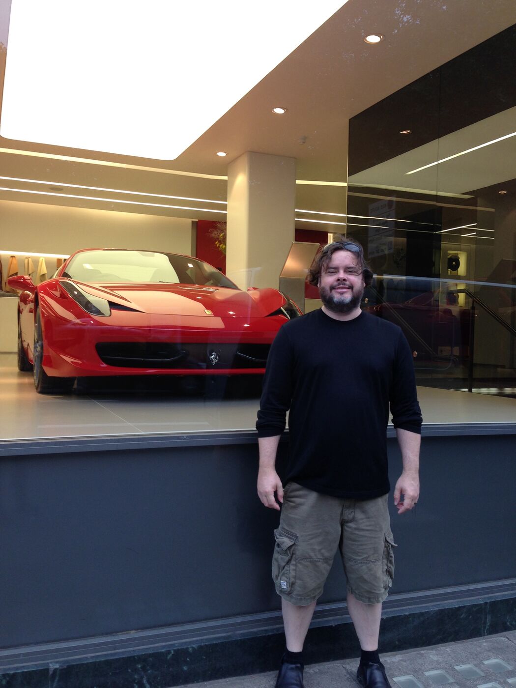 Steve standing beside a red Ferrari